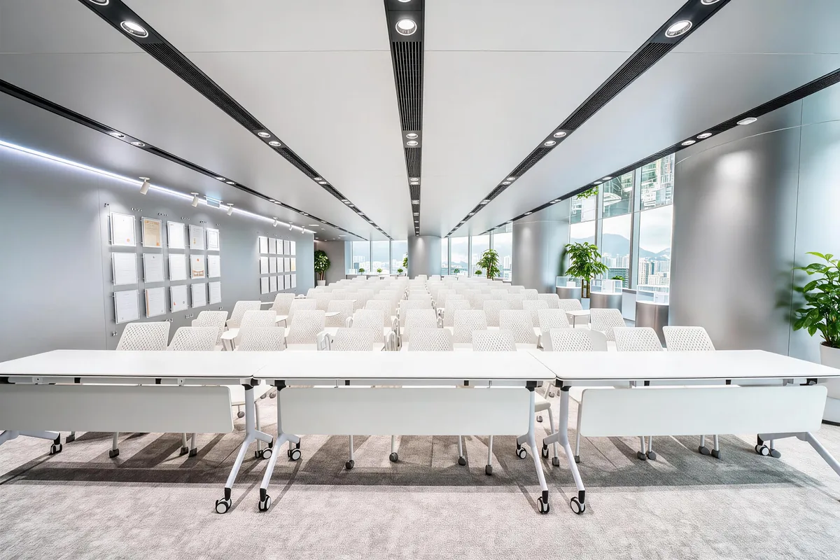 Completed window-side conference room with rows of white chairs and tables.