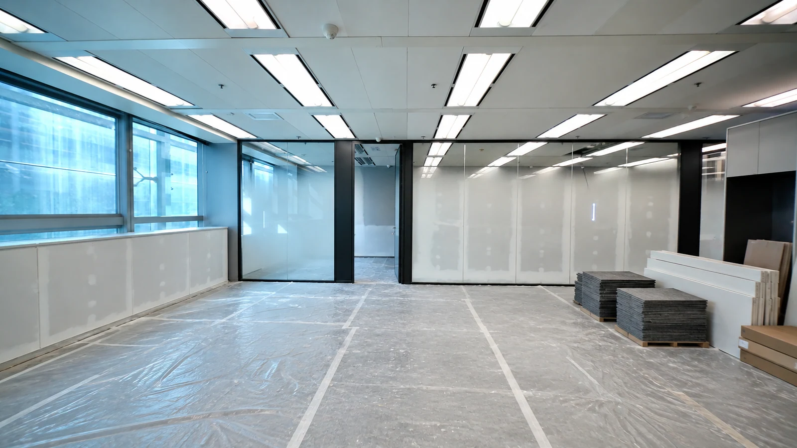 AI reconstruction of the same office during fit-out, with an unfinished floor and materials awaiting installation.